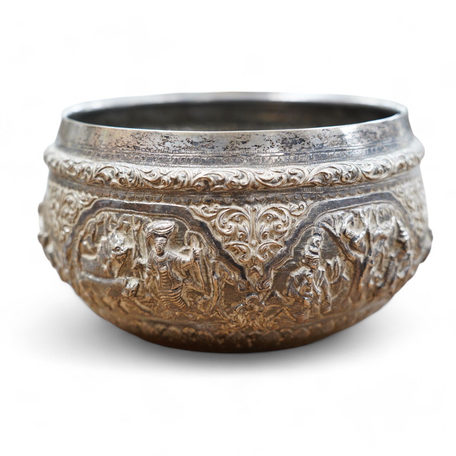 An early 20th century Indian white metal fruit bowl, embossed with figures at various pursuits, diameter 18.5cm. Condition - poor to fair
